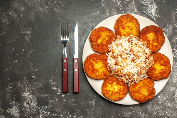 top view tasty fried cutlets with cooked rice dark floor photo dish meal meat - Картофельные котлеты по-белорусски