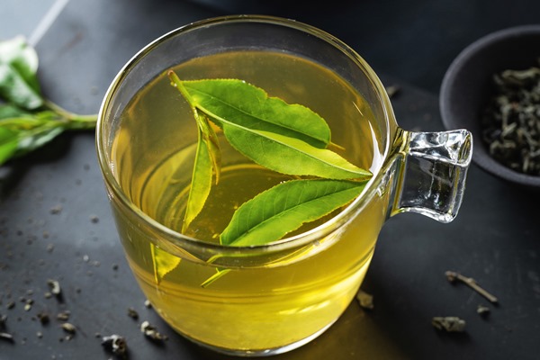 closeup of brewed green tea in cup served on plate on table 1 - Чай марокканский