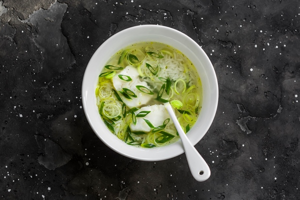 Уха с рисом и пореем cod leek and rice broth on a dark background top view delicious soup for lunch - Уха с рисом и пореем