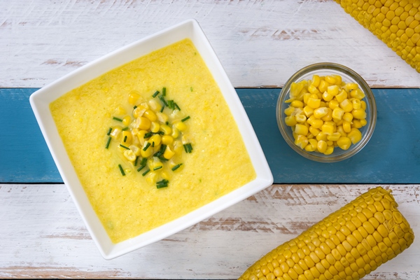Постная кукурузная каша corn soup in white bowl on white and blue wooden table top view - Постная кукурузная каша