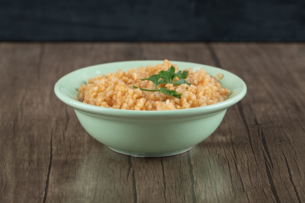 Отварной булгур с луком и чесноком delicious bulgur with greens on green plate - Отварной булгур с луком и чесноком