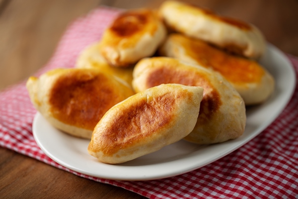 pirozki malen kii pirog s masom na tarelke - Сырные пышки с ветчиной
