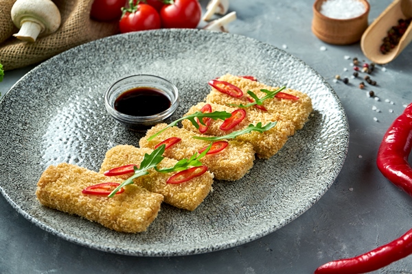breaded fried tofu with soy sauce chili pepper plate gray background - Тофу с нори в кляре