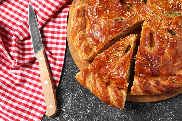 cut delicious homemade pie knife black table flat lay - Постный дрожжевой пирог с солёными грибами