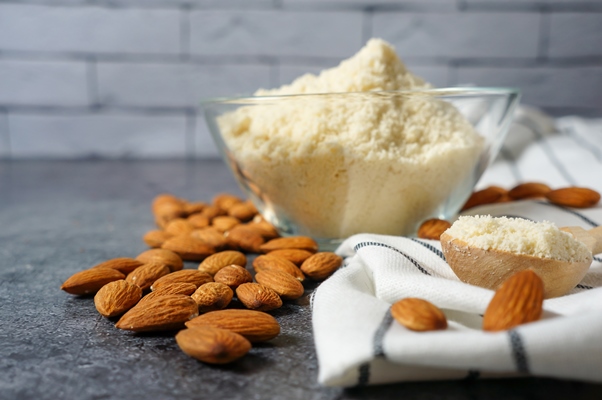 fresh almond flour glass bowl almonds dark concrete background copy space - Лествицы из миндального песочного теста
