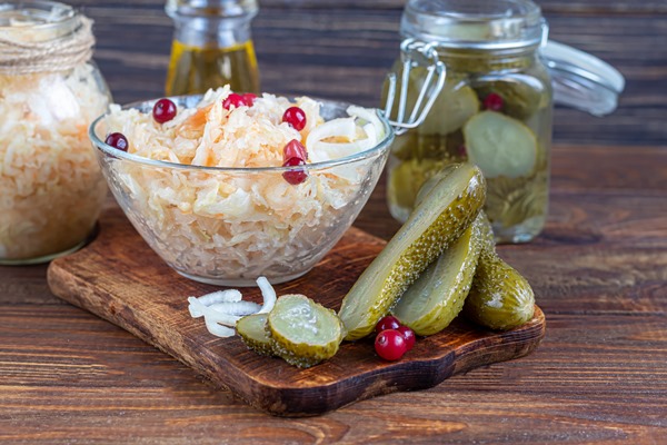 Салат из квашеной капусты и солёных огурцов pickled cucumbers glass jar wooden board sauerkraut with cranberries fermented food copy space - Салат из квашеной капусты и солёных огурцов
