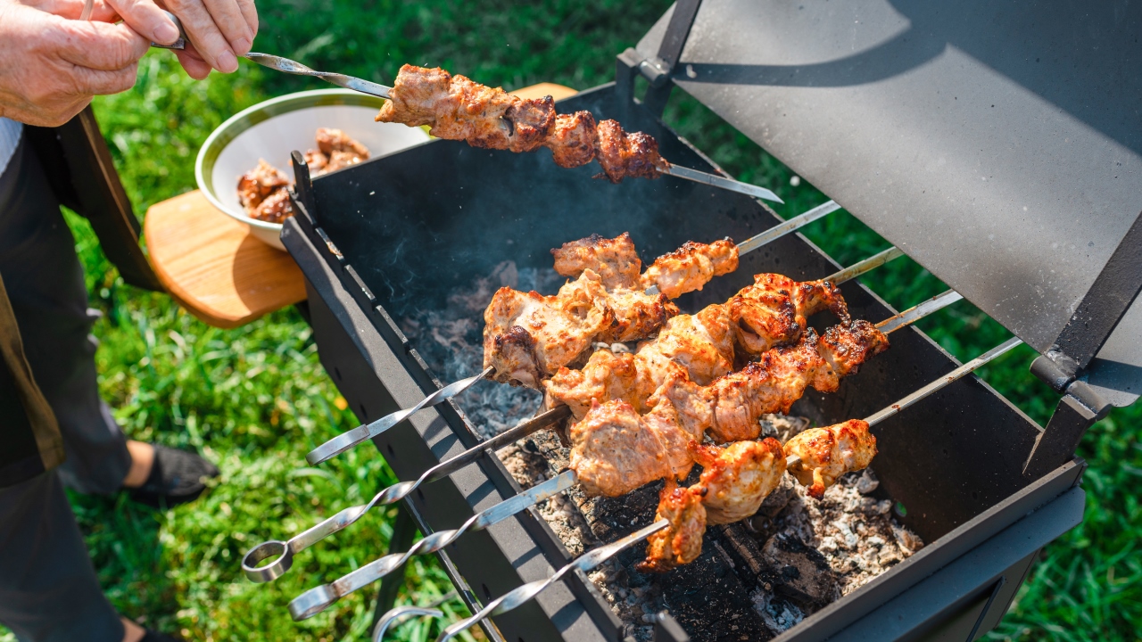Шашлык в горчично-медовом маринаде с лимоном и луком senior woman doing process cooking barbecue completed metal grillcooking picnicdelicious juicy aromatic pieces shashlikmeadow background - Шашлык в горчично-медовом маринаде с лимоном и луком